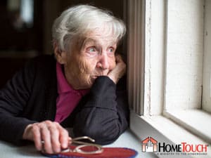 HomeTouch - Elderly woman looking out the window.