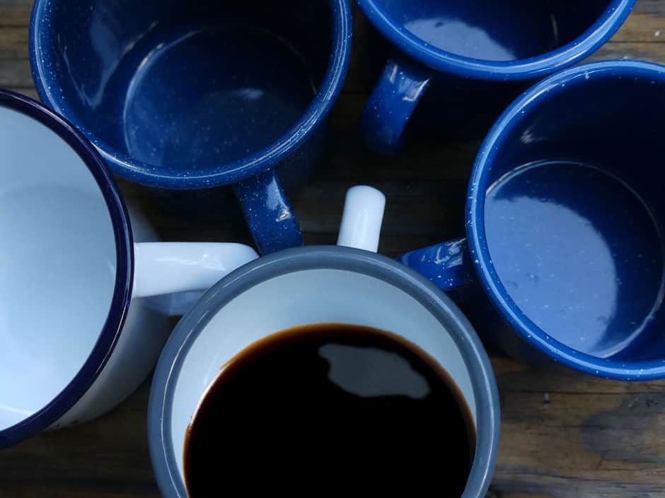 Four empty coffee mugs and one partially filled mug